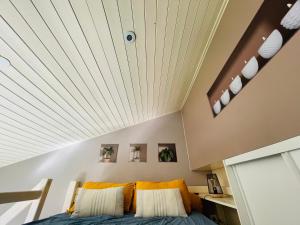 Posto letto in camera con soffitto bianco. di La lumière du lac a Veyrier-du-Lac