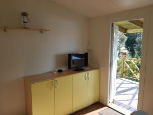 una habitación con TV en un armario y una puerta en Naturist Mobile Homes Eden in FKK Ulika, en Poreč