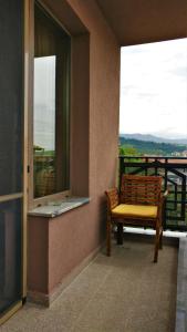 einen Balkon mit einer Bank und einem Fenster mit Aussicht in der Unterkunft Къща за гости Роял in Sandanski