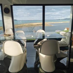 a conference room with a glass table and chairs at Villa l'hermine Vue mer exceptionnelle, prestation luxe contemporaine avec cinema et spa, borne voit électrique in Perros-Guirec