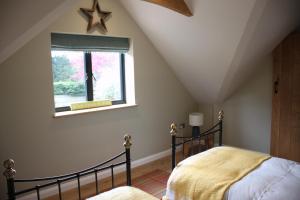 ein Schlafzimmer mit einem Bett und einem Fenster in der Unterkunft Wonderfully Spacious Luxury Holiday Cottage in Billingshurst