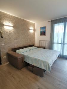 a bedroom with a large bed and a chair at Casa Pina in Tignale