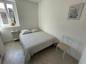 ein kleines Schlafzimmer mit einem Bett und einem Stuhl in der Unterkunft Les Appartements Chambon in Sarlat-la-Canéda