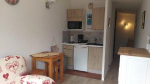 Una pequeña cocina con una mesa y una silla. en studio plein sud vue Mont Blanc CHAMONIX, en Chamonix-Mont-Blanc