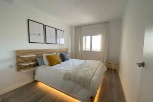 Un dormitorio con una gran cama blanca y una ventana en AMPLIO APARTAMENTO SEAVIEW en Salou