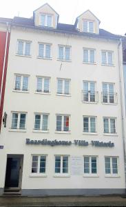 a white building with a sign on the side of it at Villa Viktoria 1 in Ingolstadt