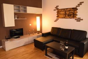 sala de estar con sofá y TV en Casa Mascarella, en Bolonia