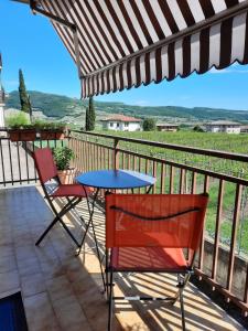 een patio met een tafel en stoelen op een balkon bij Mary House in Negrar