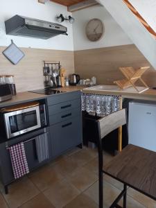 uma cozinha com um fogão, um micro-ondas e uma mesa em La charentaise ch d'hôtes ,Studio em Chérac