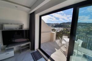 Cette chambre dispose d'un balcon avec une grande fenêtre. dans l'établissement The Diamond Apartment, à San Pawl il-Baħar