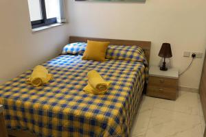 - une chambre avec un lit doté de draps jaunes et d'oreillers jaunes dans l'établissement The Diamond Apartment, à San Pawl il-Baħar