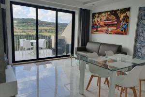- un salon avec une table en verre et une salle à manger dans l'établissement The Diamond Apartment, à San Pawl il-Baħar