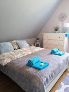 um quarto com uma cama com toalhas azuis em Ostoja Kaczórki em Kaczórki