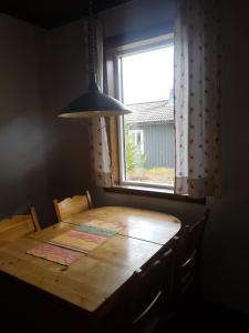 una mesa de madera en una habitación con ventana en Björnbyn Stugby, en Råda