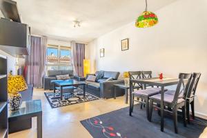 sala de estar con sofá, mesa y sillas en Appartement idéal pour chiller au soleil !, en Fuengirola