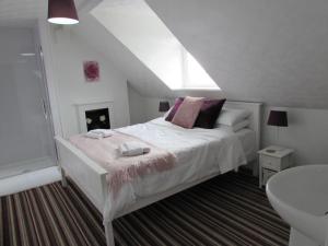 een slaapkamer met een wit bed en een raam bij The Loft Apartment in Weymouth