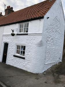 a white building with a red roof at Mena Cottage, Cosy Country and Quaint. in Hunmanby