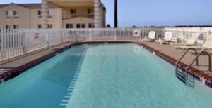 Una gran piscina con sillas y un edificio. en Days Inn by Wyndham Butler, en Butler