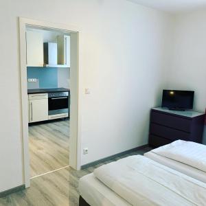 a hotel room with two beds and a kitchen at Pension Belo Sono München in Munich
