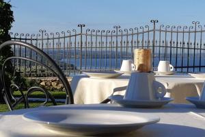 a table with white tables and chairs with a view of the ocean at Casaliva Relais in Bardolino