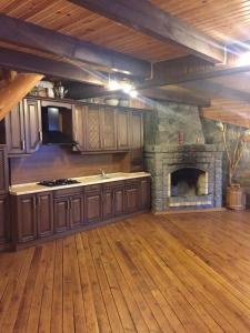 cocina con chimenea de piedra en una habitación en Будинок для відпочинку в лісі, en Berëzovka