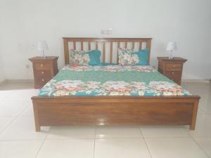 a bed in a bedroom with two night stands at Residence Delaure in Bingerville