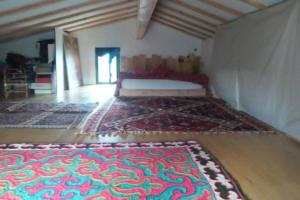 Habitación con cama y alfombra en el suelo en Gîtes de Revirand en Sarras