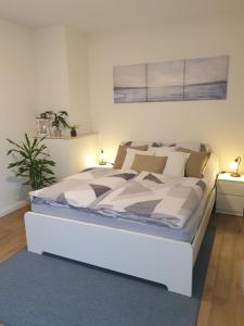 Ferienwohnung Einfeld في نويمونستر: سرير أبيض في غرفة بها