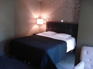 um quarto com uma cama grande e um cobertor azul em Hotel La Fayette em Rochefort