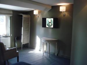 Cette chambre sombre dispose d'un tabouret et d'une photo sur le mur. dans l'établissement Hotel La Fayette, à Rochefort