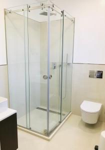 eine Glasdusche im Bad mit WC in der Unterkunft Fleur de Lis in Belas