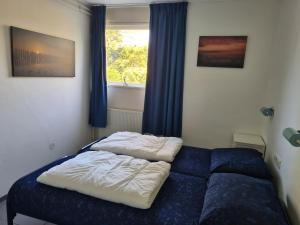 Una cama en un dormitorio con ventana. en De Duinrand, en Oostkapelle