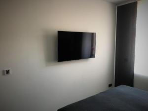 een flatscreen-tv op een witte muur bij FAMILY APARTMENTS - SALZHAUSBLICK FERIENWOHNUNGEN - TOP INNENSTADT LAGE am SALZHAUS STADTZENTRUM mit HOTELBETTEN in Zittau