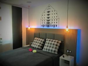 1 dormitorio con 1 cama y un edificio en la pared en FAMILY APARTMENTS - SALZHAUSBLICK FERIENWOHNUNGEN - TOP INNENSTADT LAGE am SALZHAUS STADTZENTRUM mit HOTELBETTEN, en Zittau