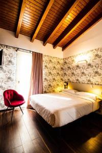 a bedroom with a large bed and a red chair at Molino Candeal Hotel Boutique & Apartamentos in Caniles