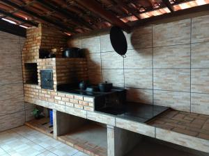 uma cozinha com um fogão numa parede de tijolos em Recanto Malop em Três Marias