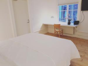 een slaapkamer met een wit bed en een raam bij Prästgården Hotell & Bryggeri in Söderhamn