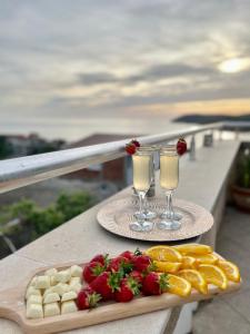 een dienblad met eten en twee glazen champagne op een tafel bij Apartments Moracanin in Sutomore