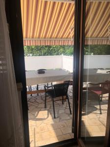 a glass door leading to a patio with a table and chairs at Apartment Tea in Rab +10 photos