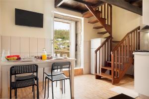 una cocina con mesa y sillas y una escalera en Quinta dos Campos - Chalé, en Braga