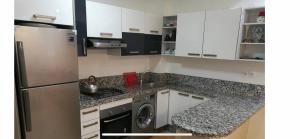 una cocina con nevera y lavadora en Ola Blanca Kiki, en Sidi Rahal
