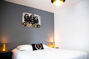 a bedroom with two beds and a painting on the wall at Hôtel & Gastronomie - La Table de l'Europe in Villeréal