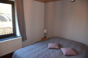 1 dormitorio con 1 cama con 2 almohadas rosas en Chez Pèpère, gîte charmant et tranquille, en Trois-Ponts