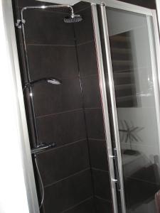 een douche met een glazen deur in de badkamer bij Hotel La Fayette in Rochefort