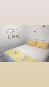 a bedroom with a bed with a sign that reads all you is need love at Holiday house Dalinda in Dražice