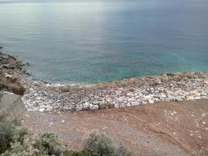 a rock retaining wall next to the water at Caletta Beach in Castiglioncello