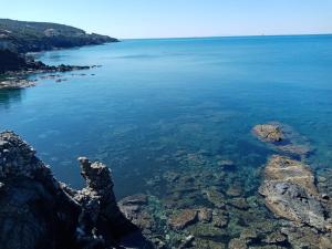 a view of a body of water with rocks at Caletta Beach in Castiglioncello