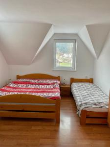 a bedroom with two beds and a window at Chalupa Synka in Terchová