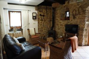 a living room with a leather couch and a fireplace at Casa Rural Moradiellos in Arenas de Cabrales