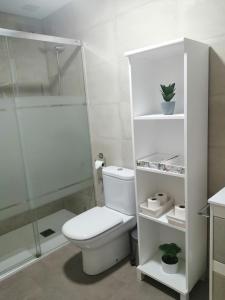 uma casa de banho branca com um WC e um chuveiro em Apartamento adosado cerca del mar em Gran Alacant
